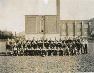 Park City High School Football Team outside the old high school (now PC Library), fall 1936. Mel is shown standing on the far right in a white shirt.