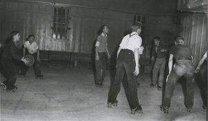 L to R: Cliff Roach, Don Young, Cliff Street, Bud Tessman, Mel Fletcher, John Novak playing rollerskate basketball. One of the many invented sports for past time in PC. With baskets already in the Elks Hall, all that was needed was Parrish rental skates.