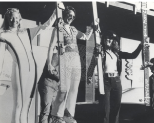 Suzy Chaffee, Karen Huntoon, and Penelope Street standing on an awards platform, circa 1970s.